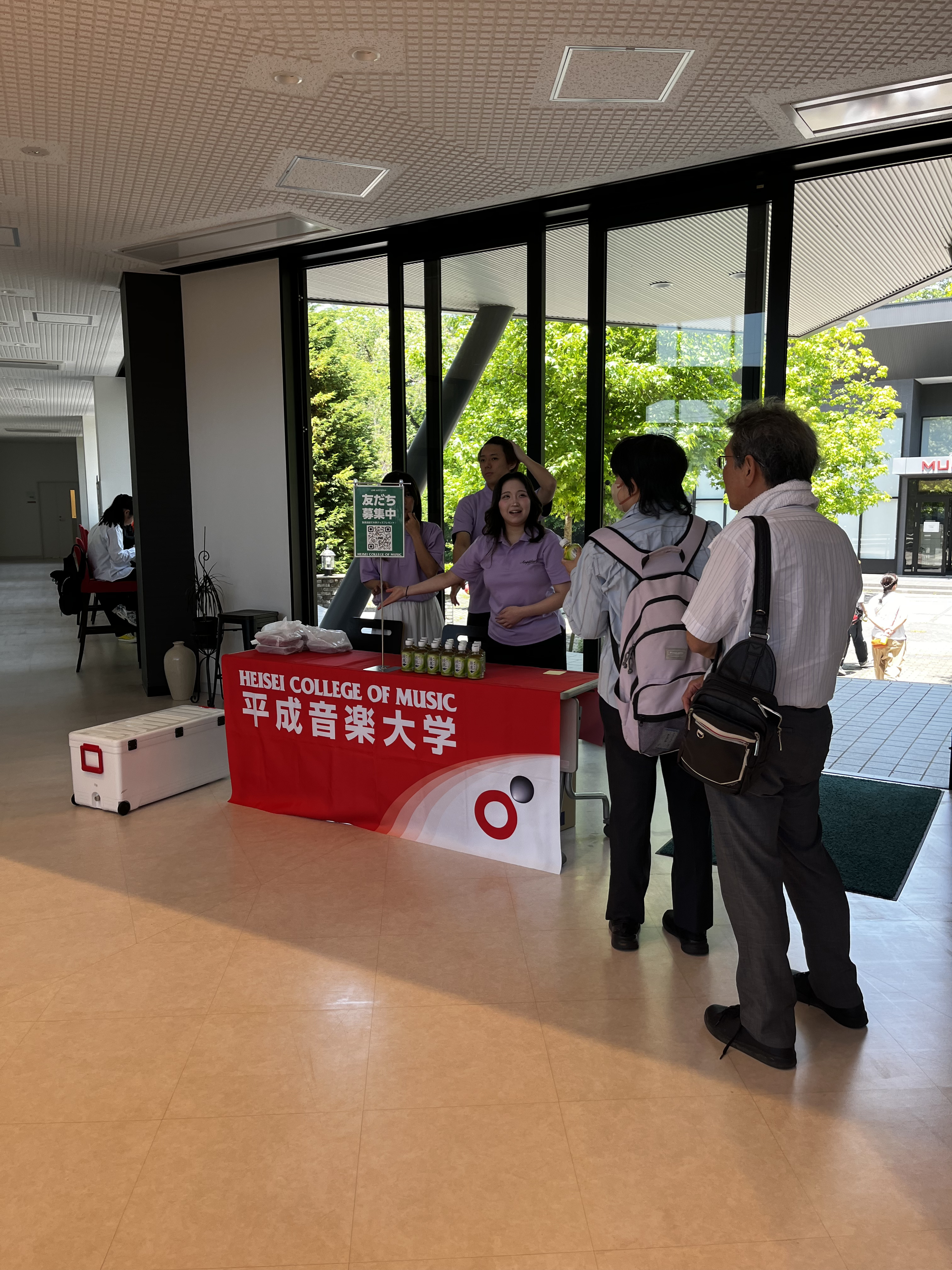 LINE登録エリアで軽食を配る学生
